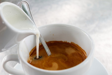 Pouring milk into cup of energy