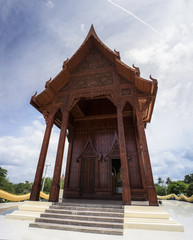 wide view of thai beautiful wooden temple,thai style carving of temple in prachuapkhirikhan province of Thailand,blue sky and cloud in background