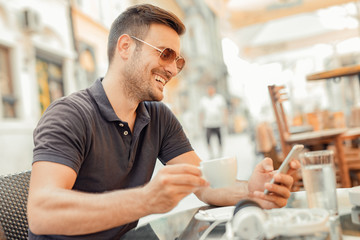 Young man using smart phone in cafe