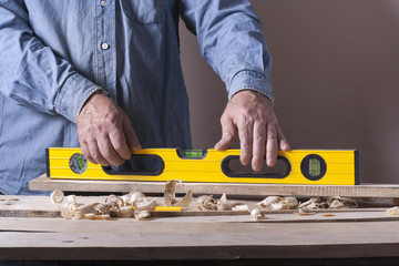 Carpenter working with plane on wooden background at Building Site. Joiner workplace