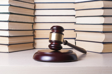 Law concept - Book with wooden judges gavel on table in a courtroom or enforcement office.