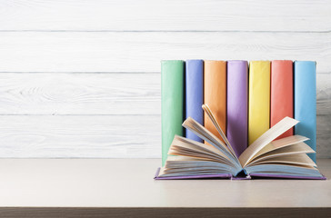 Open book, hardback books on wooden table. Education background. Back to school. Copy space for...