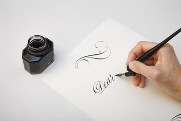 Writing with quill pen. Spilled ink and fountain pen concept image for writing process. Vintage nib pen and inkwell
