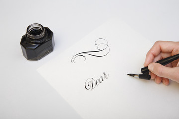 Writing with quill pen. Spilled ink and fountain pen concept image for writing process. Vintage nib...