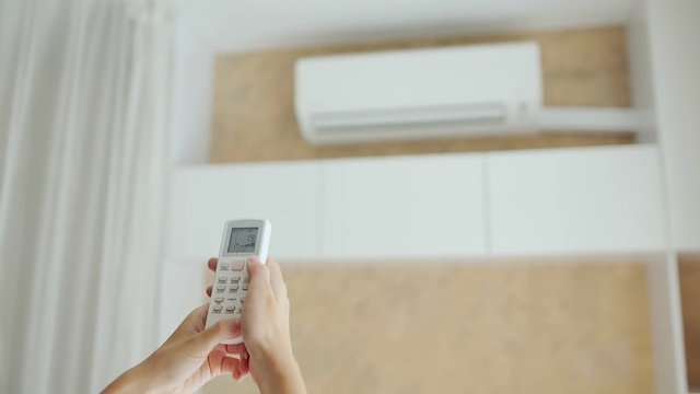 Turning on split system air conditioner with remote control.