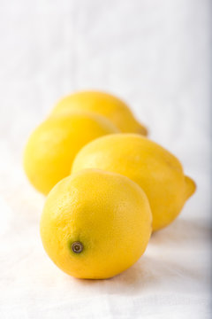 organic, fresh lemons over a white background with copy space, close up, vertical