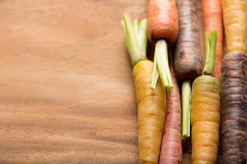 colorful carrots on wooden cutting board, copy space, top view, horizontal