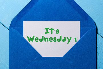 It's Wednesday on sheet of paper in blue envelope. Happy week concept