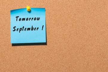 Tomorrow September written on a sticker at notice board with empty space for text
