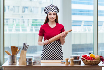 Woman with rolling pin isolated on white