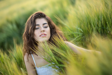 Girl sits in rye field