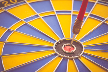 Red dart arrow put on center of dartboard. Abstract business success in KPI, target, goal, objective.