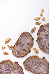 slices of walnut bread, layed out over white background with walnuts around, copy space, vertical