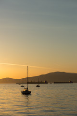 sailboats and freight ships at sunset in English Bay, Vancouver, BC