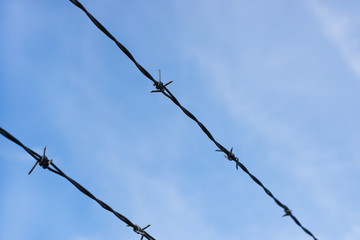 close up of a metal wire fence around a construction area with a perfect blue sky, copy space