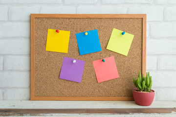 Cork board and color paper note on white background.