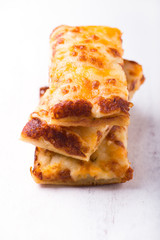 stack of cheese pizza slices, close-up and isolated on white rustic wooden background