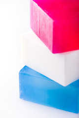 stack of home made, organic, plant-based soap bars in red, white and blue colors, vertical, close up