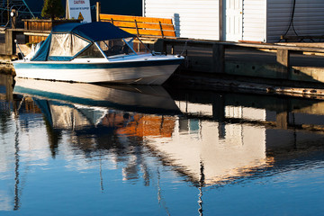 small, private speed boat docked at sunset in marina