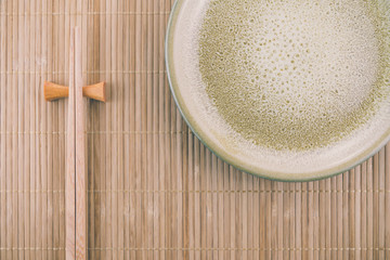 Flat lay handmade dish on Japanese mat background with sushi chopsticks