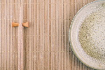 Flat lay handmade dish on Japanese mat background with sushi chopsticks