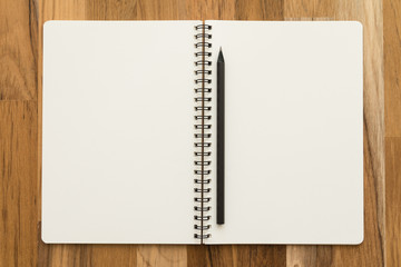 Blank empty notepad and pencil on wooden table background - Business and education concept.