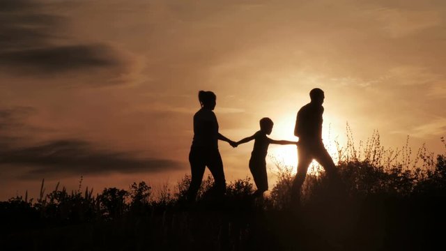 Silhouette, happy children with mother and father, family at sunset, summertime