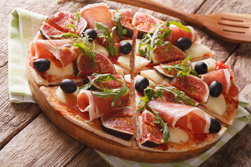 pizza with figs, prosciutto, herbs, olives and mozzarella closeup. Horizontal
