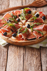 pizza with figs, ham, arugula, olives and mozzarella cheese. vertical
