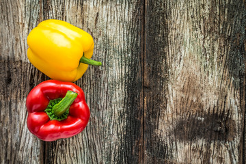 Yellow and red sweet pepper on wooden