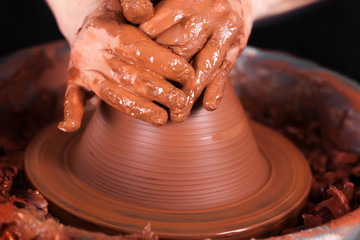 Potter shaping clay on the pottery wheel