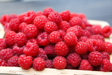 Wicker basket with raspberries closeup