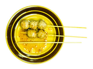 Five meatballs on brown dish with isolated background