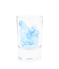Shot glass full of softgel pills isolated