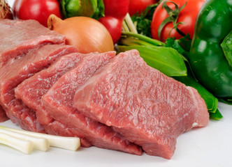 Slices of pork with vegetables close up