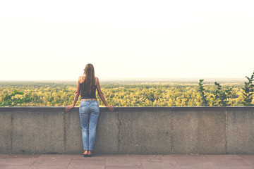 Romantic woman looking into the distance on a beautiful landscap