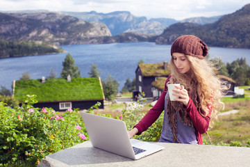 Freelance girl working on laptop in nature and beautiful landscapes