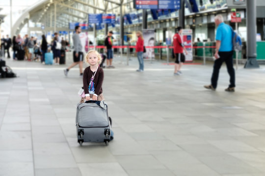 Kleines Mädchen mit koffer im flughafen