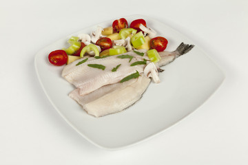 Fototapeta na wymiar fillet on a white plate and fresh vegetables