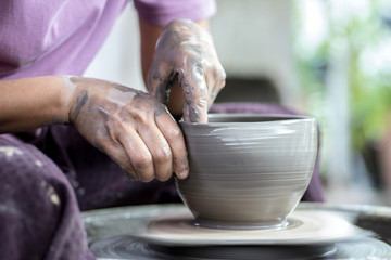 Hands working on pottery wheel