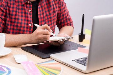 Cropped image of young male graphic designer at desk.