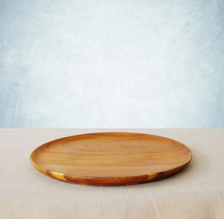 Empty round wooden tray on linen tablecloth background