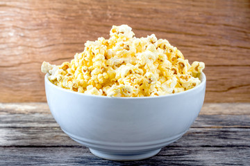 Popcorn in  bowl over on wooden background