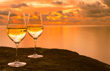 Pair of wine glasses against a beautiful tropical sunset. 