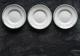 Empty plates on the black ceramic background