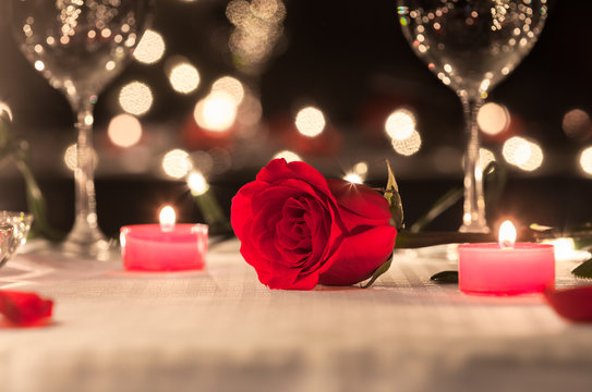 Beautiful single rose in a romantic dinning setting. First date. 