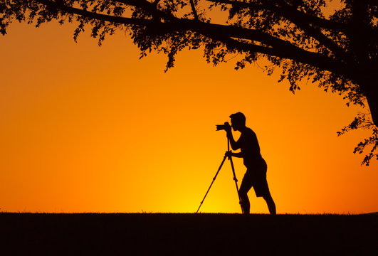 Male photographer taking photos of a beautiful sunset. 