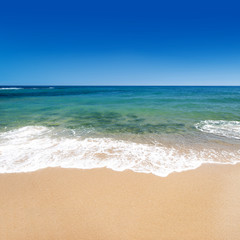 Fototapeta na wymiar Calm sea with golden sand and blue sky