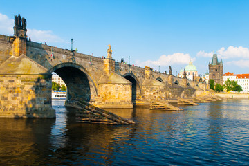 Fototapeta na wymiar Charles Bridge, aka Karluv most, and Vltava river in Prague city centre on sunny summer day with blue sky, Czech Republic