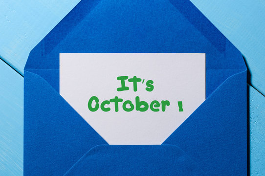 It's October - sign on paper at open blue post envelope. Autumn time concept
